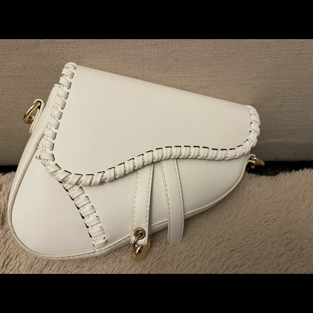 White shoulder bag, it looks like the Dior Saddle silhouette